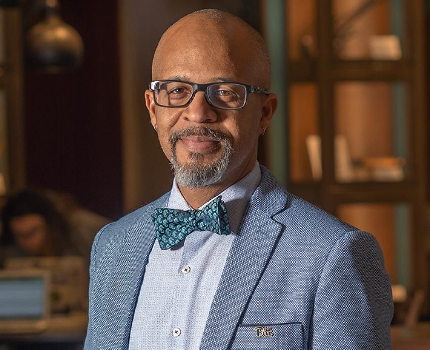 Gabby Yearwood wearing grey suit with patterned blue bowtie