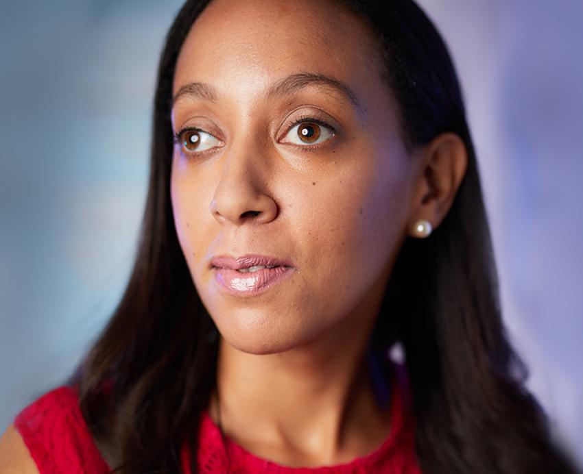 Haben Girma wearing red shirt in front of blue background