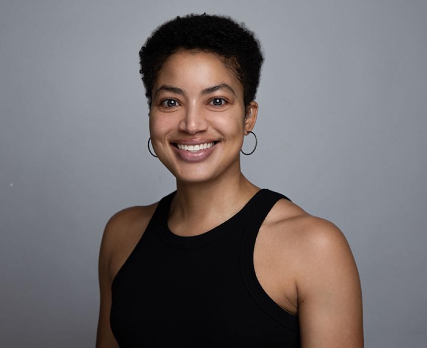 Alaina Roberts smiling in black shirt in front of grey background