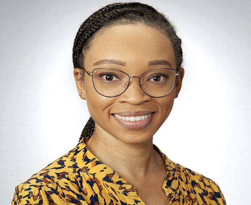 Amber Johnson wearing yellow and black patterned shirt in front of white background