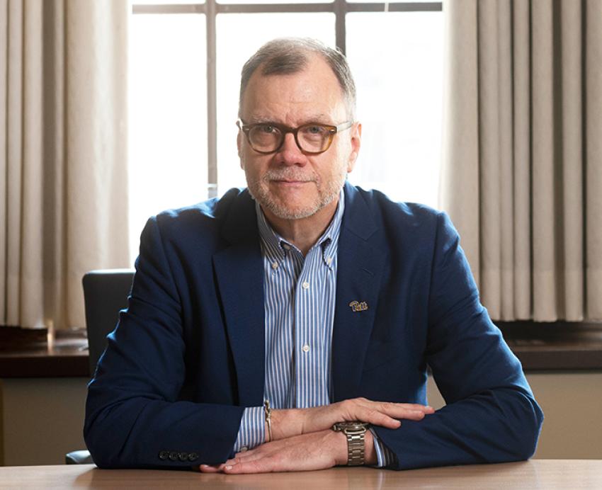 Rob Rutenbar wearing dark blue suit and sitting at a desk 