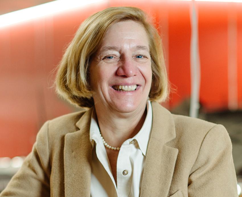 Sabina Deitrick smiling and wearing beige jacket over white shirt
