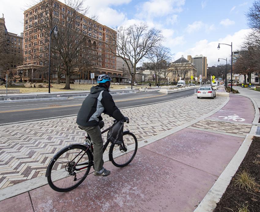 Man riding in bike lane on campus street