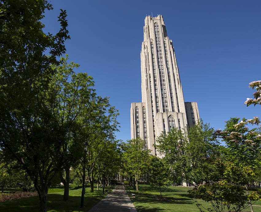 Cathedral of Learning behind trees on a sunny day