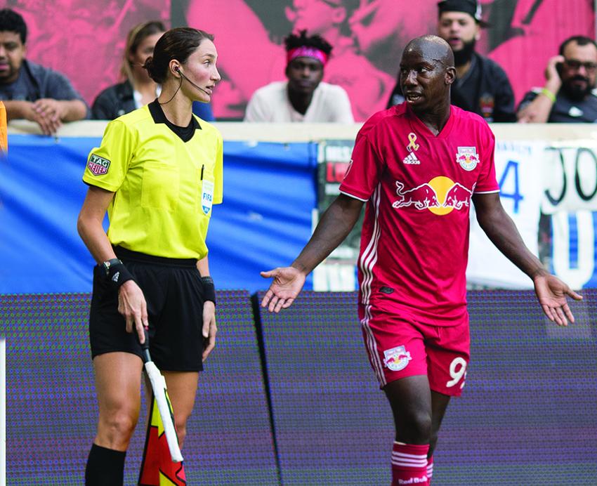 Kathryn Nesbitt talking to soccer player on the field