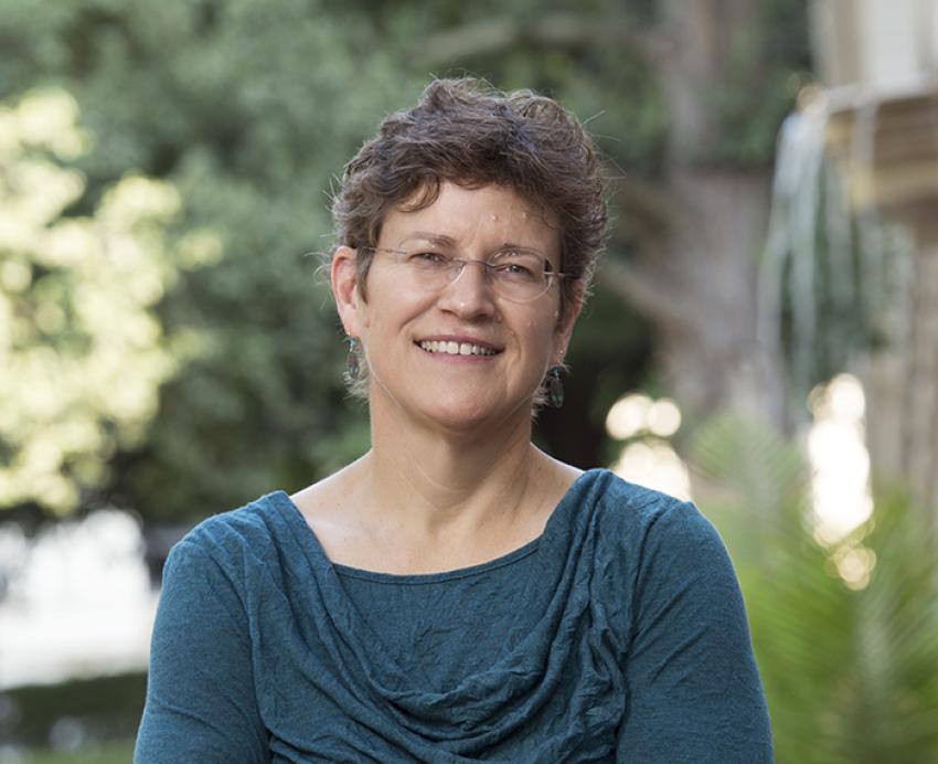 Elizabeth Farmer in blue shirt standing outside 