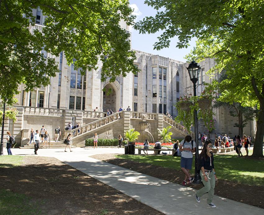Pitt people walking around Cathedral of Learning in spring