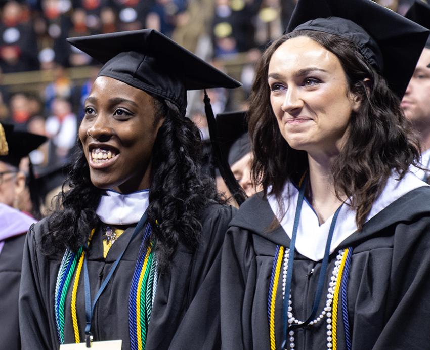 Graduating students smiling in the crowd 