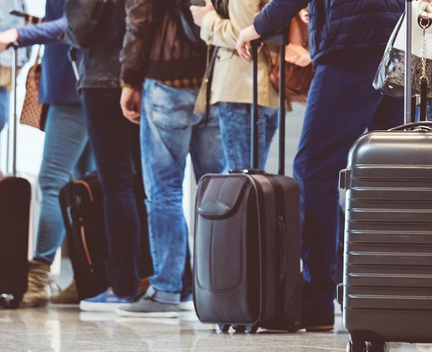 a line of people with rolling suitcases