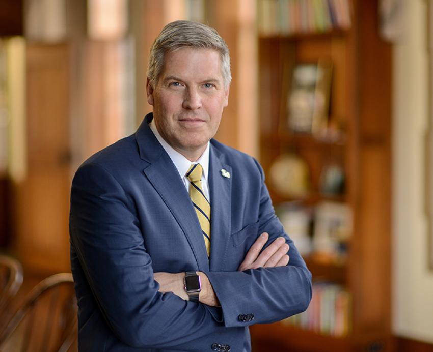 Chancellor Patrick Gallagher standing with arms folded