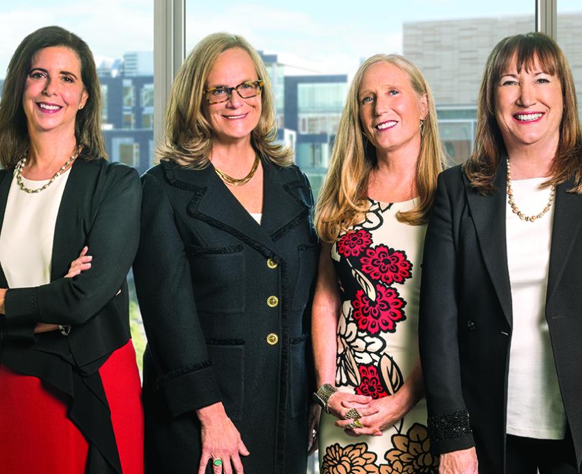 The four authors of "The No Club" standing together in front of large window