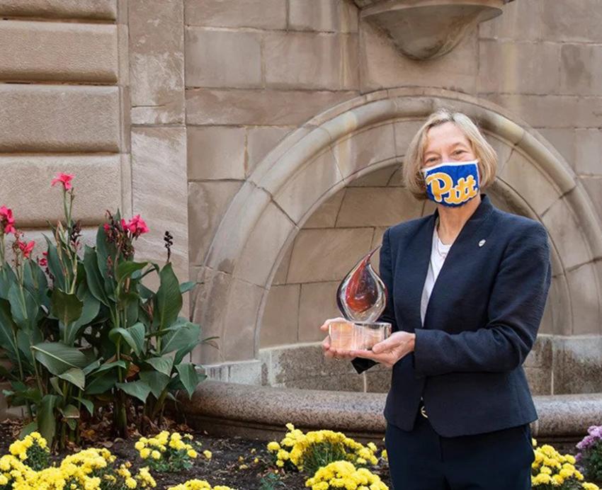 Two people, a man and a woman, in Pitt face masks and suits