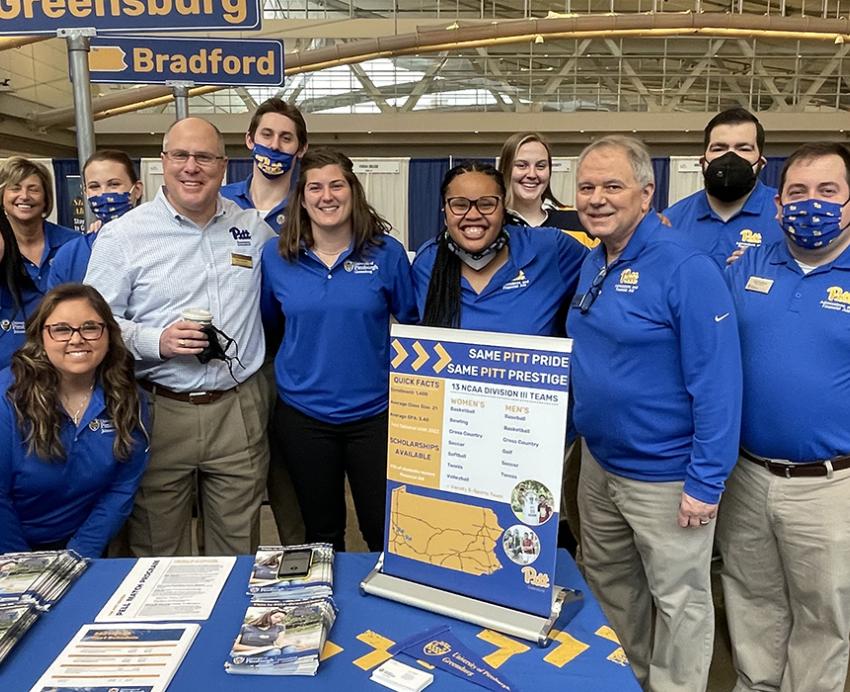 Pitt people standing together behind table