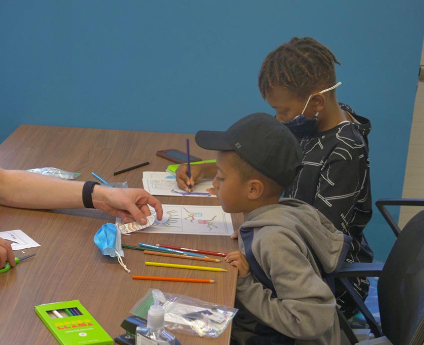 a Pitt person helping two kids color