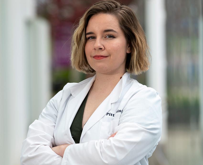 a person in a white coat with her arms crossed