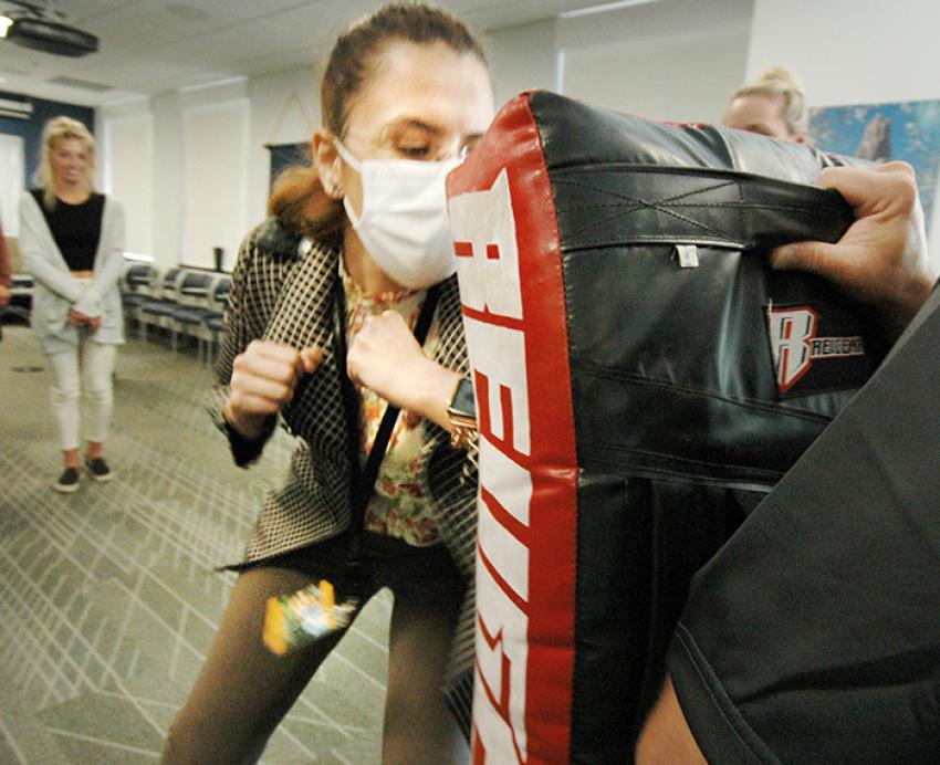 a person elbowing a large pad in a training