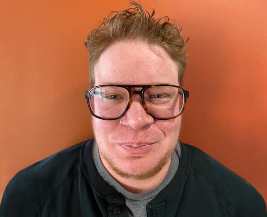 a person in front of an orange background