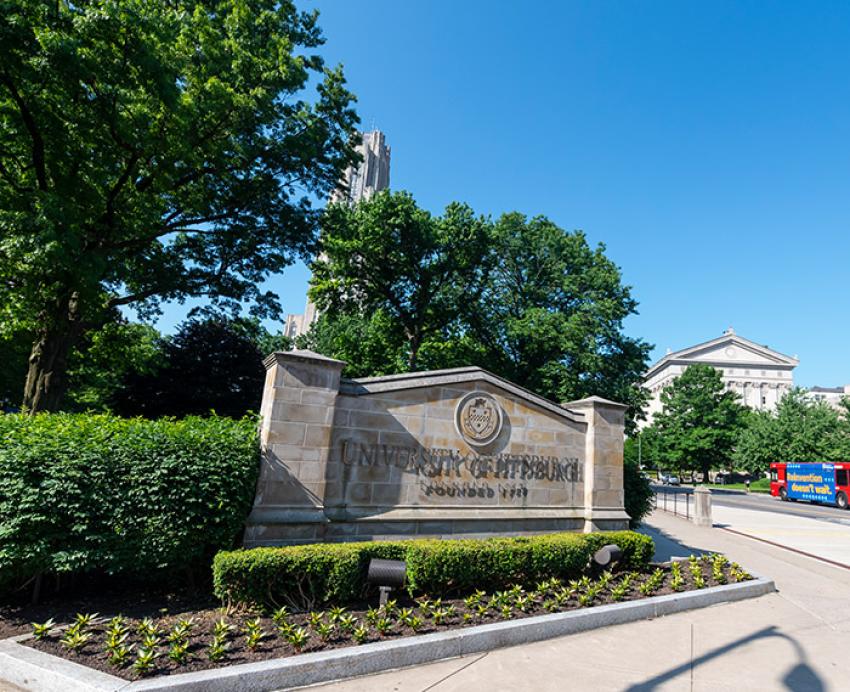 a Pitt sign outside the Cathedral on a blue-sky day