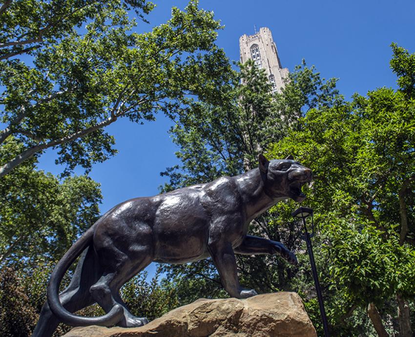 a panther statue in front of trees and the Cathedral