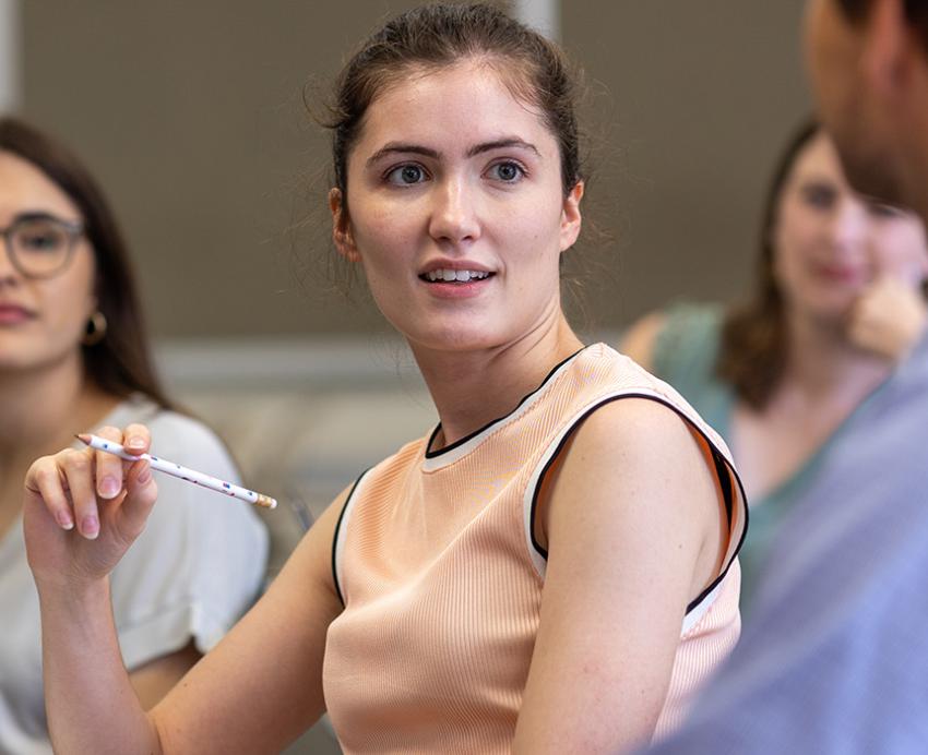 a person at a desk holding a pencil