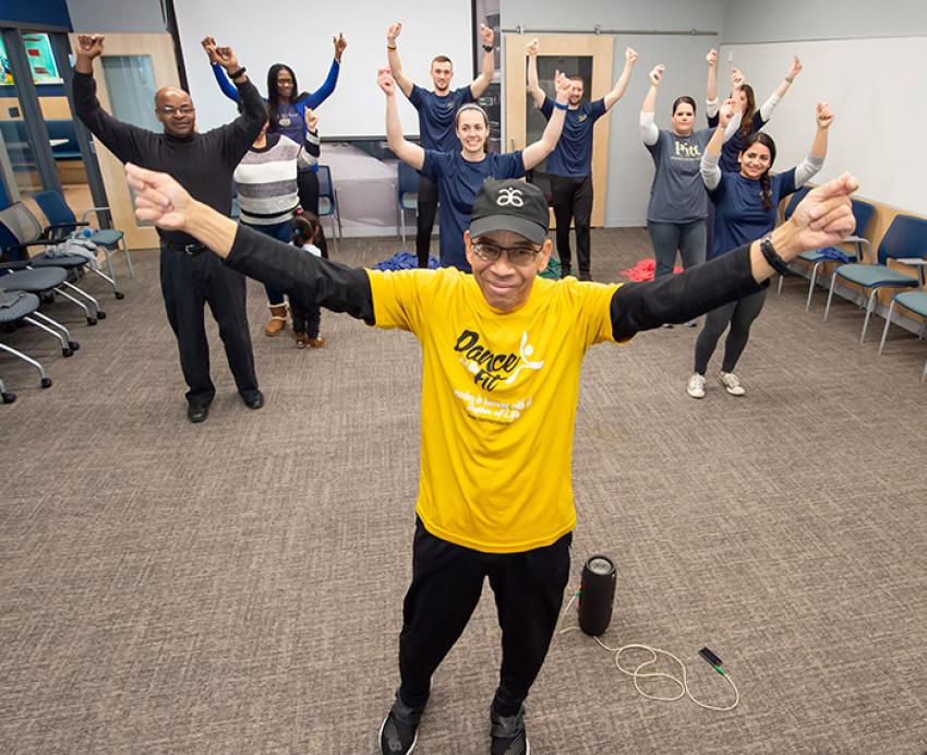 a group of people with their arms raised in a CEC room
