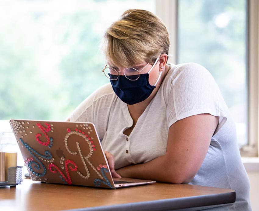 a person at a laptop with rhinestones on the case