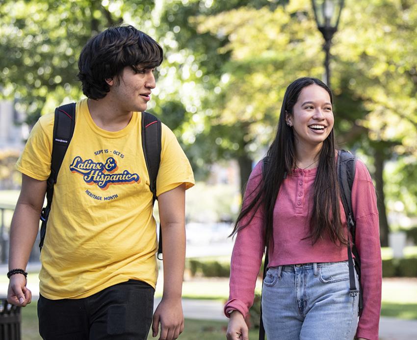 three students smiling, one wearing an LHHM shirt