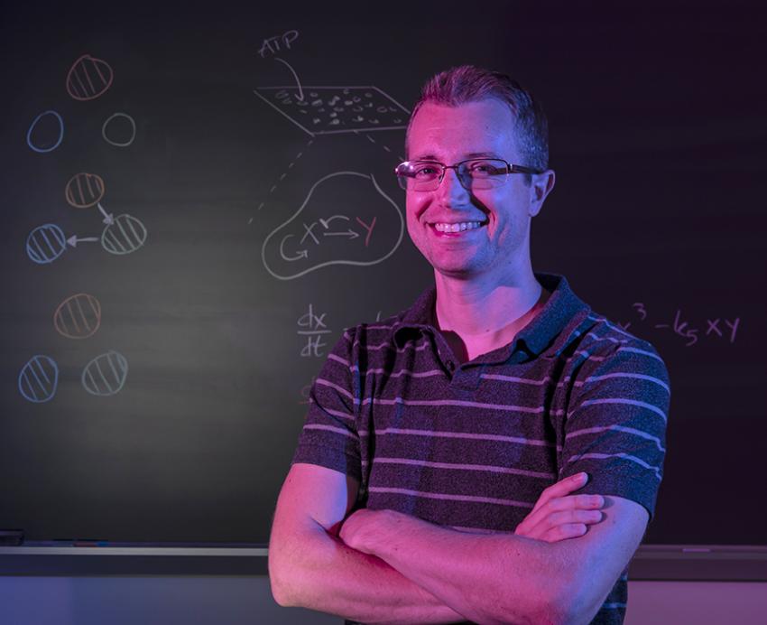 two people lit by magenta light at a chalkboard