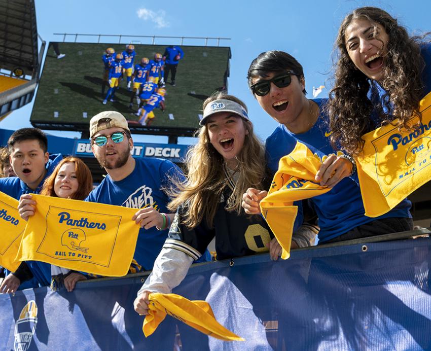 students cheer at homecoming football game