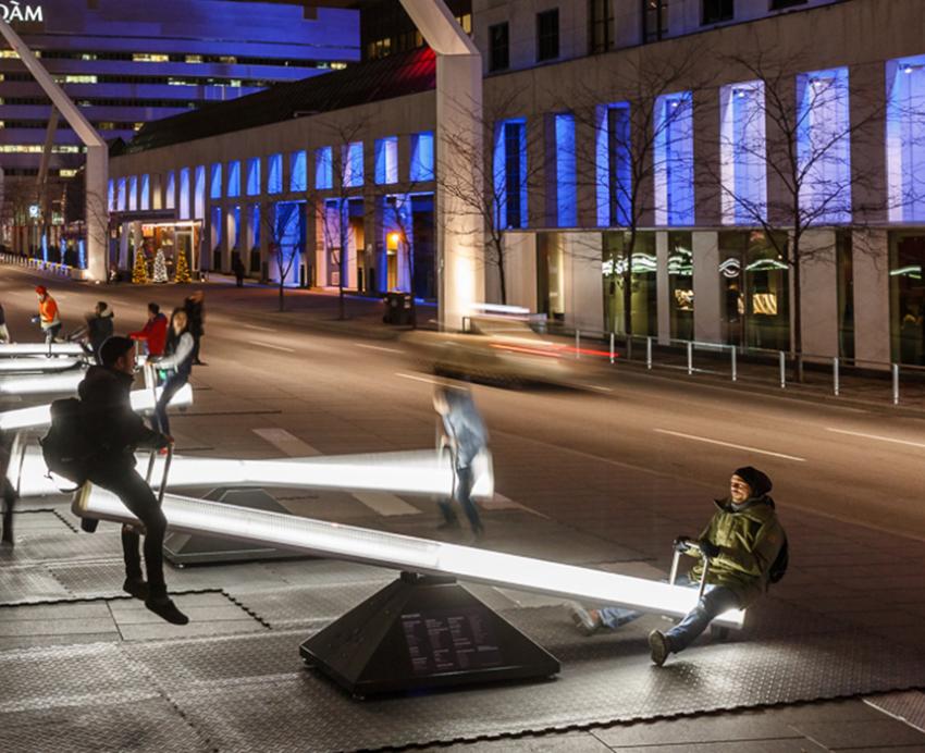 people playing on many illuminated seesaws