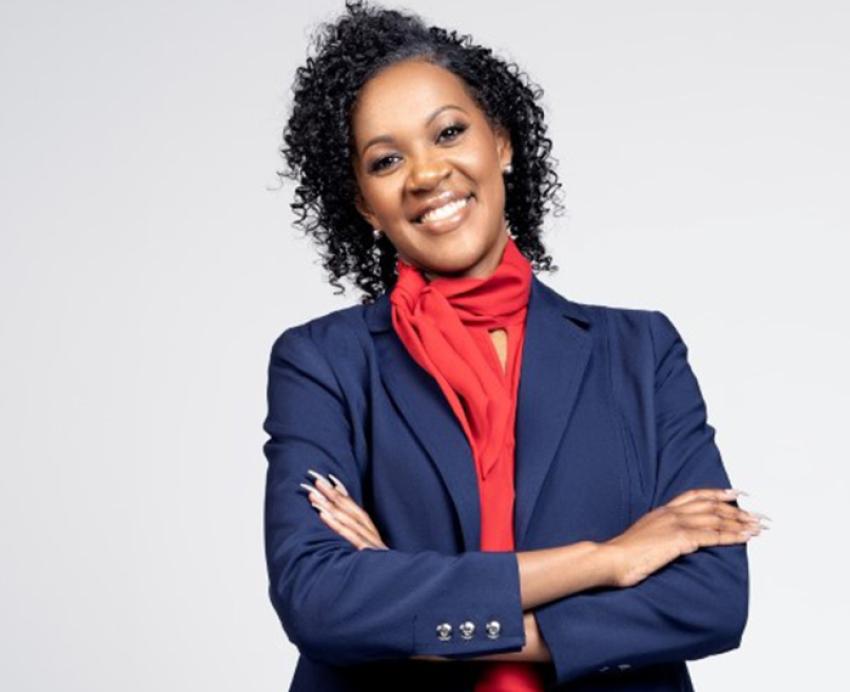 Deans in a red blazer with her arms crossed