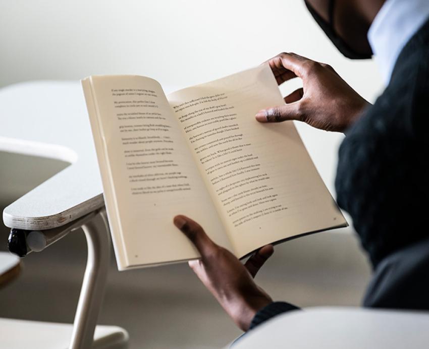 A person reads a book in a classroom