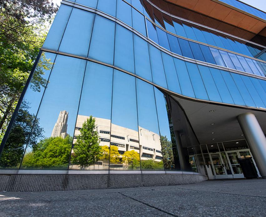 A reflection of the Cathedral of Learning in the windows of Mervis Hall