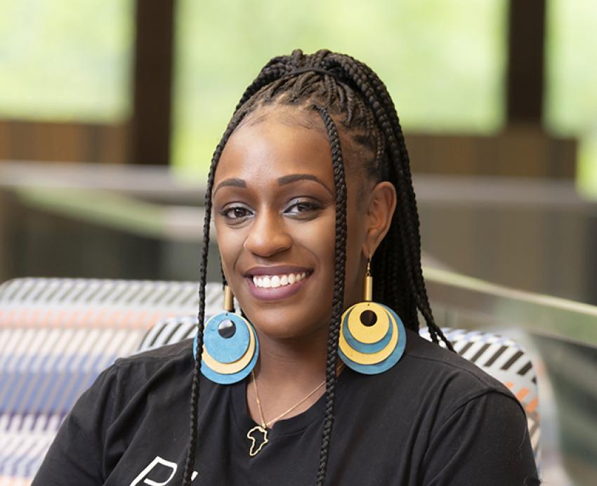Brianna Ross sits wearing a black shirt that reads Black teachers matter