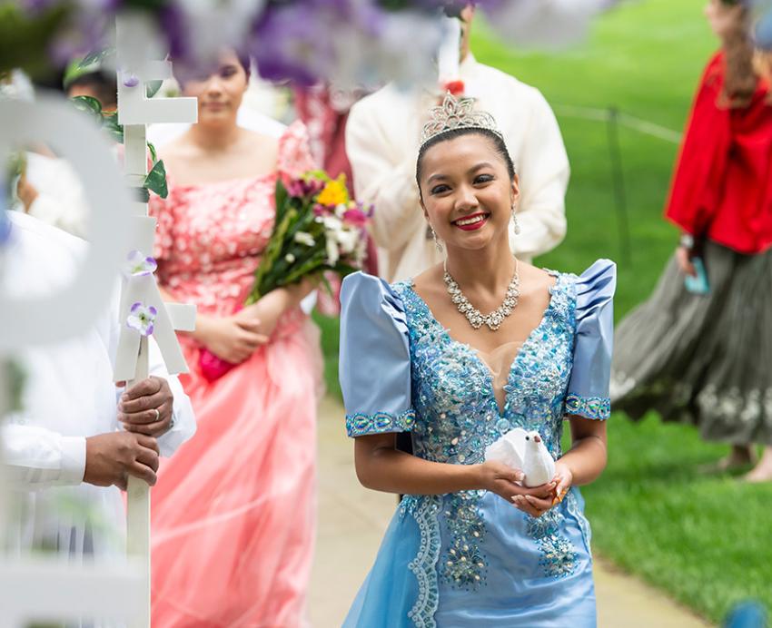 A person in a traditional Philippine dress walks in a procession