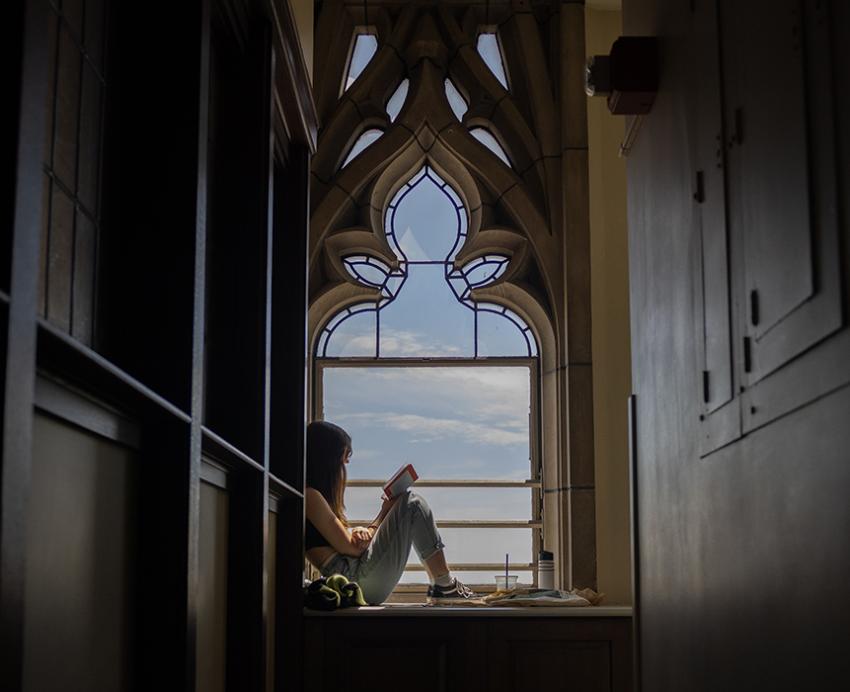 A person reads at a window in the Cathedral of Learning