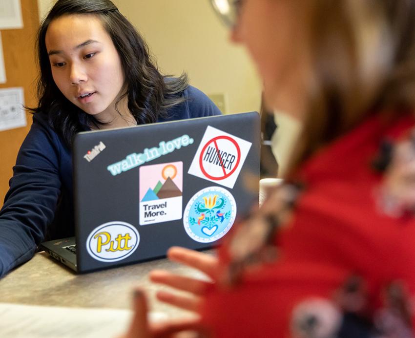Two people discuss an assignment while studying in a dorm on the Bradford campus