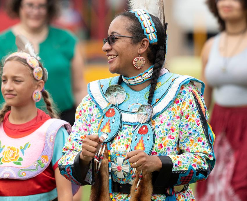 An indigenous person in traditional attire at a powwow