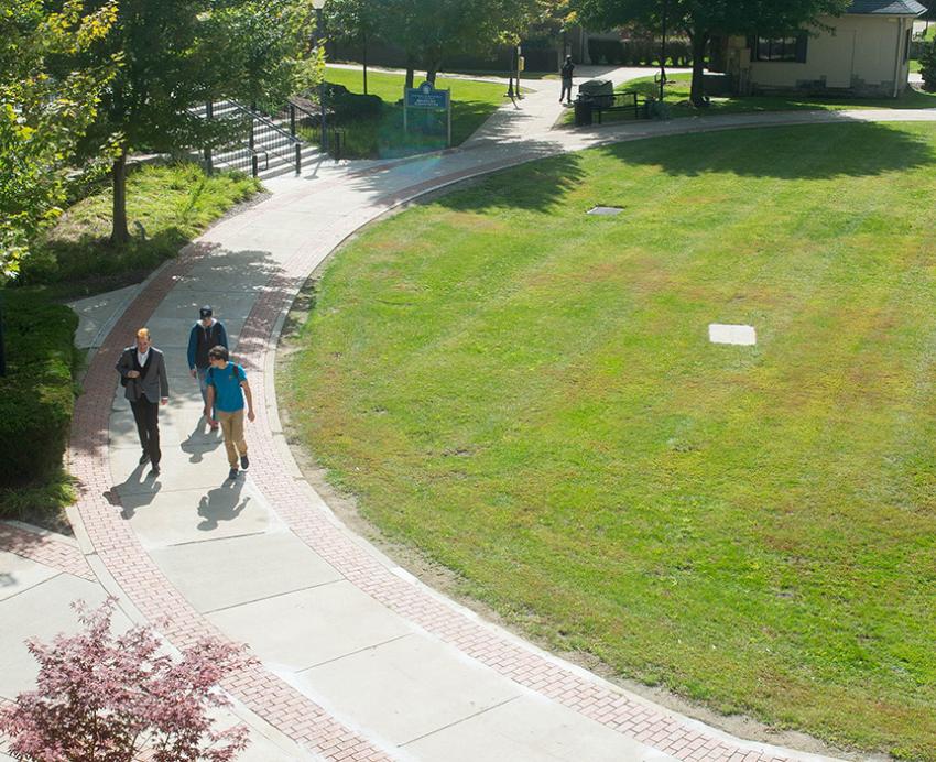 A drone shot of people walking by a lawn on Pitt-Titusville's campus