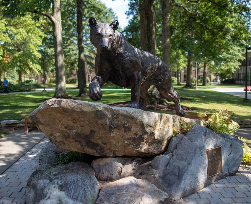 A bobcat statue atop a rock