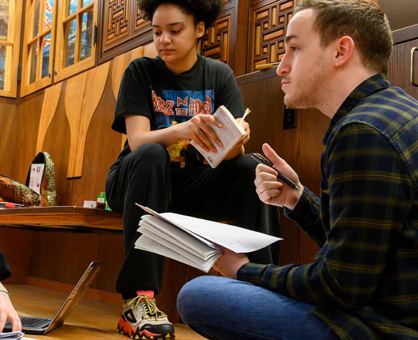 Students study front papers and laptops on the floor