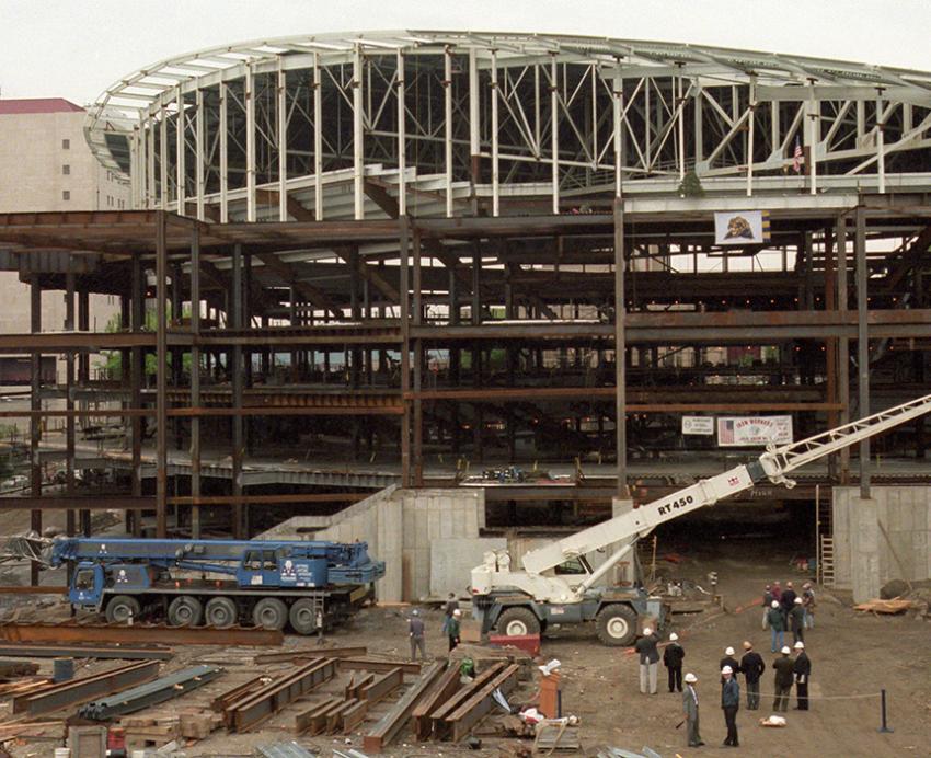 A crane lifts beams during construction of the Petersen Events Center