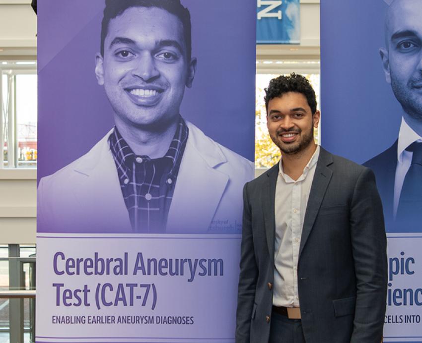 Mittal stands next to a poster with his photo and project name