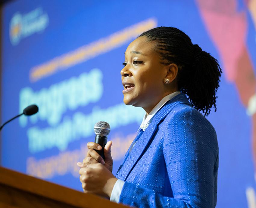 Jamilah Ducar holds a microphone at a podium
