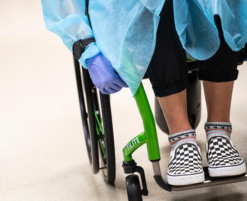 A close-up shot of a gloved hand gripping a wheelchair 