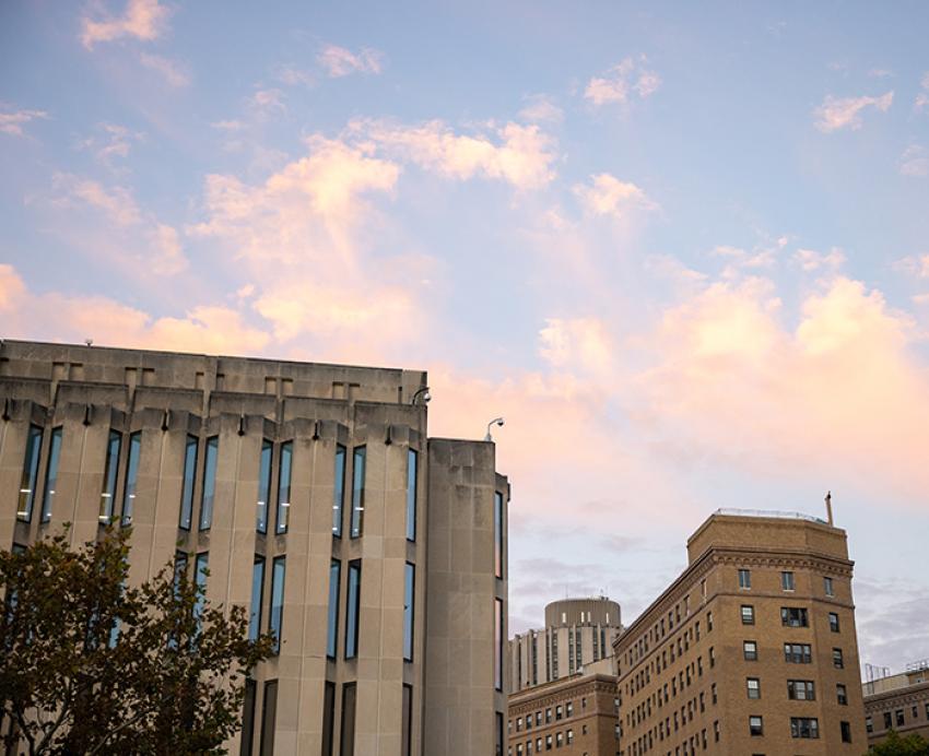 The top of Hillman Library against a blue sky and pink clouds
