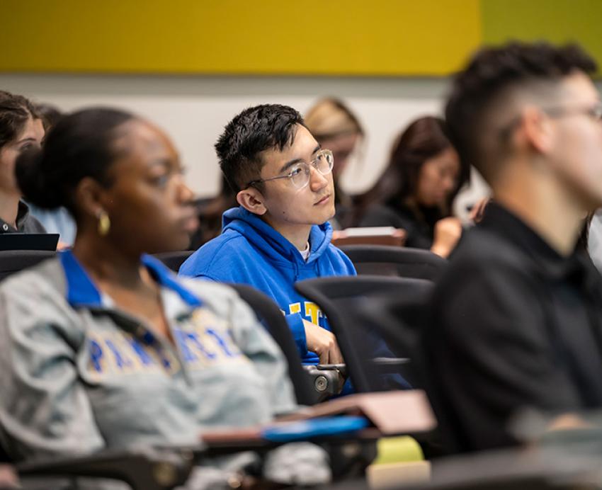 A student looks thoughtfully to the front of the classroom