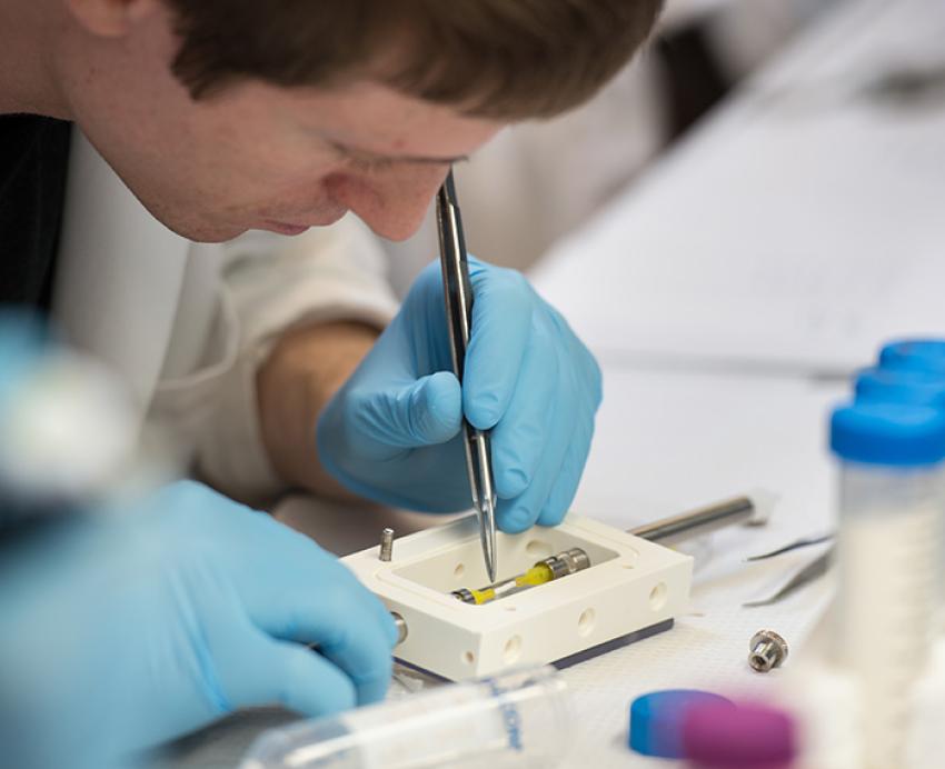 A person works on medical equipment in a lab