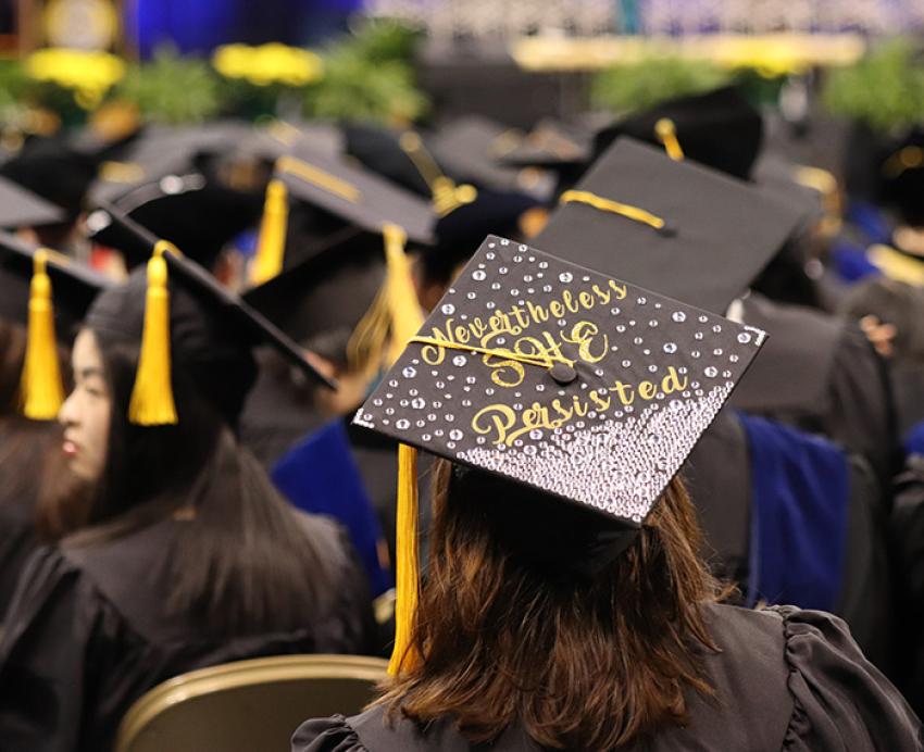 A graduation cap, decorated with rhinestones, reads Nevertheless She Persisted
