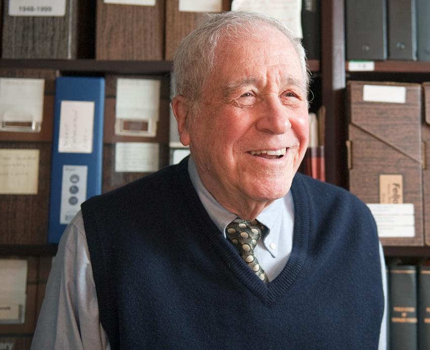 Fisher in front of a shelf of files and books